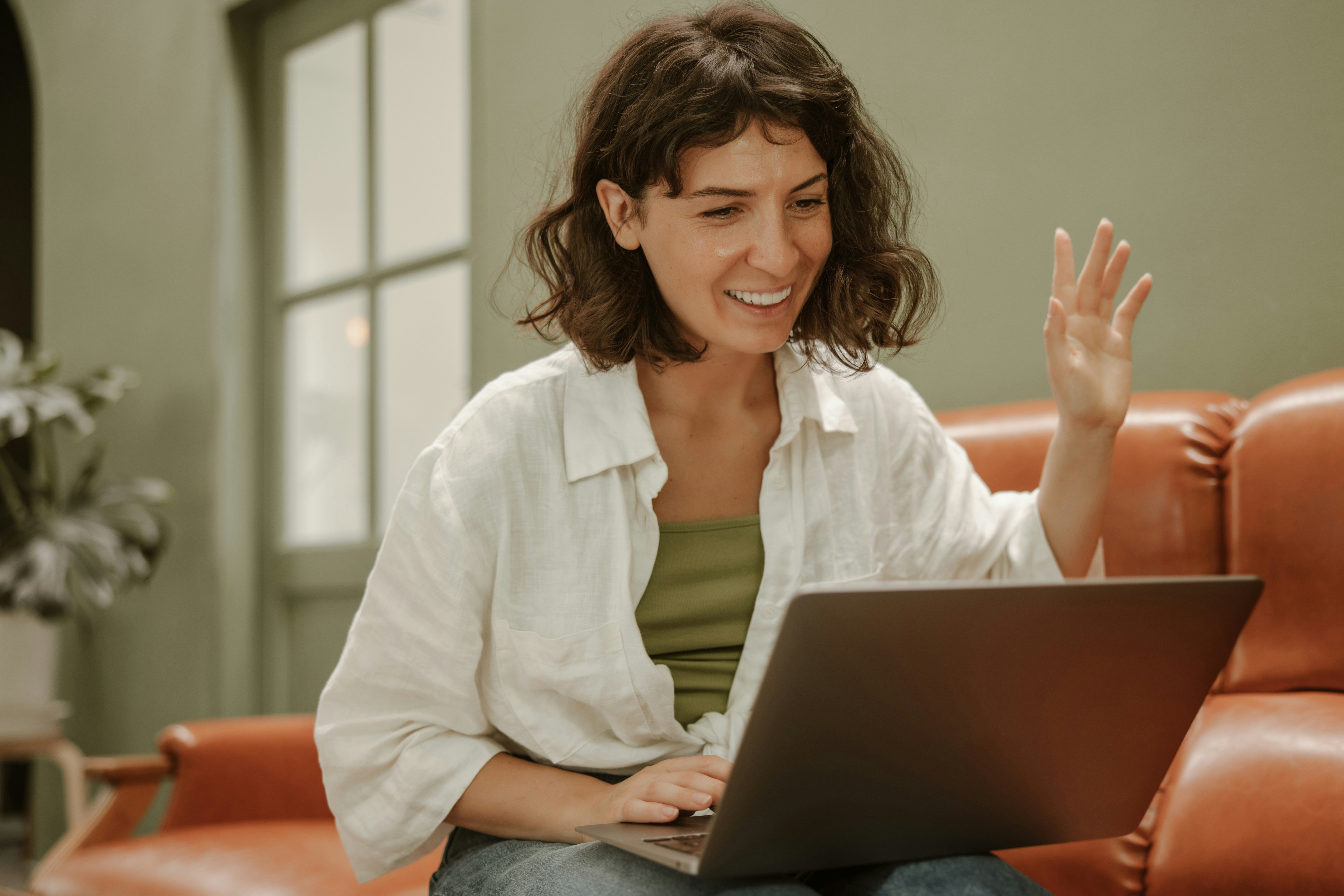 a woman sitting on a couch using a laptop computer
